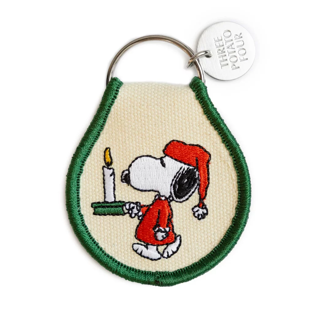 Vue du porte-clés brodé “Snoopy Christmas Cozy Night” : motif Snoopy vintage, coton Oxford, anneau métal, format compact 2.5″ × 2.25″.